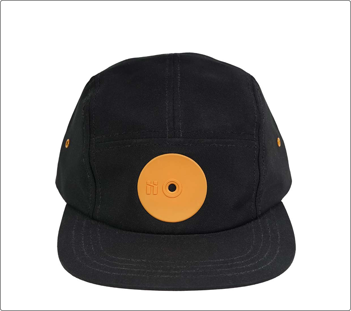 Gorra negra con visera y aplique circular naranja vista de frente